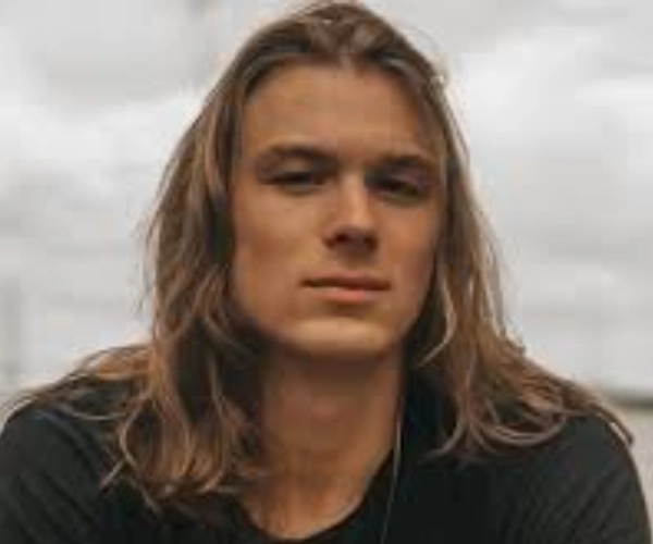 Messy, shoulder-length surfer hair for men with oblong face face